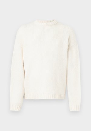 Kraftig strikket kremfarget genser med rund hals, lange ermer og ribbestrikkede mansjetter og nederkant. Myk tekstur med en litt løs passform.