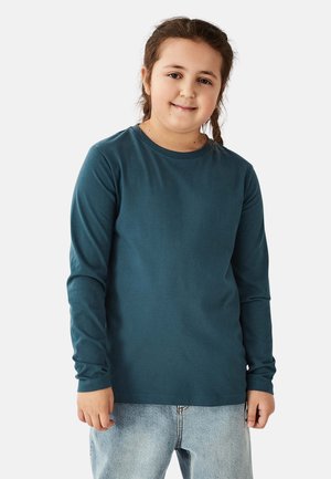 Langærmet, teal bomulds t-shirt med rund halsudskæring og blød tekstur, kombineret med lyseblå denimjeans.