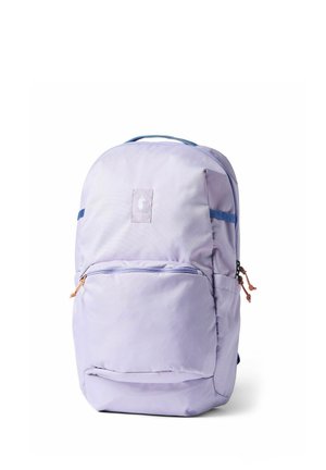 Mochila de color lavanda claro con ribete azul, asa superior, bolsillo delantero con cremallera y tiradores marrones, sobre un fondo blanco.