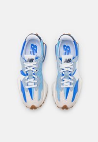 Modré a bílé tenisky kombinující semiš a síťovinu, s kulatým tvarem, gumovou podrážkou a výraznými detaily tkaniček.
