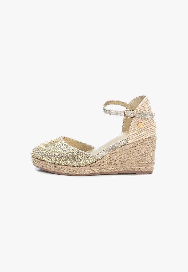 Espadrille compensée beige avec bout en or scintillant, bride à la cheville avec boucle et semelle plateforme en jute tissé.