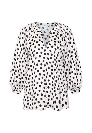 Hvid bluse med lange ærmer, løs pasform, rund halsudskæring, frontslids og uregelmæssigt mønster af sorte polkaprikker.