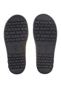 Semelles en caoutchouc de chaussures jaunes avec des motifs de semelle hexagonaux profonds et le numéro de taille 32, présentées sur un fond blanc.