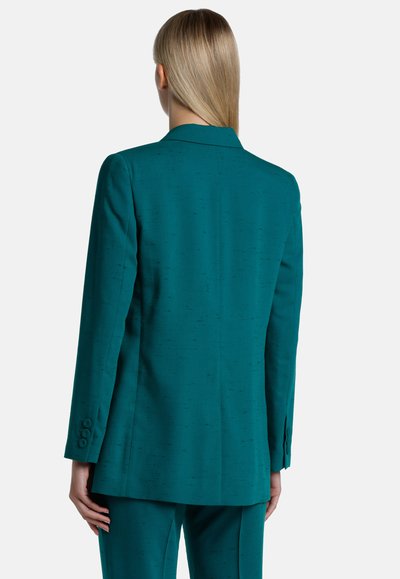 Teal tailored blazer with a smooth texture, single vent, and three-button cuffs, showcasing a clean, minimalist design.