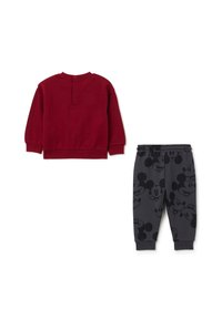 Sudadera de forro polar roja con la parte trasera abotonada, combinada con joggers gris oscuro que presentan un patrón de Mickey Mouse en negro. Ajuste suave y casual.