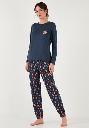 Marineblauw langemouwige pyjama-top met geborduurde peperkoekman; bijpassende broek heeft een kleurrijk, patroonontwerp van peperkoekmannen en ornamenten.