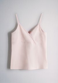 Light pink sleeveless camisole top with thin straps and a V-neckline on a plain gray background.