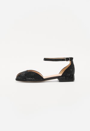 Black peep-toe sandals with ankle strap, featuring a textured woven pattern and a low block heel. Smooth leather insole with minimalistic design.