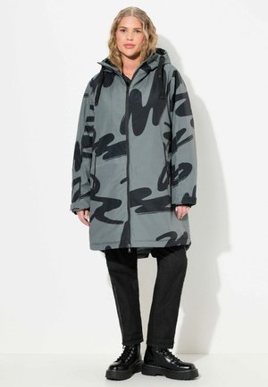 Parka impermeabile grigia con motivi astratti neri, dotata di cappuccio, zip frontale, due tasche laterali e un design fino al ginocchio.