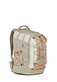 Beige Rucksack mit weißen Akzenten; verfügt über ein oranges Bungee-Kordeldesign. Hergestellt aus strapazierfähigem Stoff mit gepolsterten Mesh-Schultergurten.