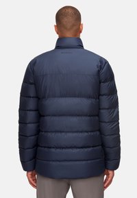 Giubbotto imbottito blu navy con baffi orizzontali, colletto alto e branding discreto, caratterizzato da una finitura liscia e lucida e polsini elasticizzati.