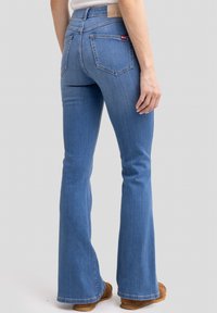 Sinine denim flared teksapüksid keskmise k�õrgusega vöökohaga. Omavad viite taskut, vöökohapaelu ja nahkplaati seljaosas vöökohal.