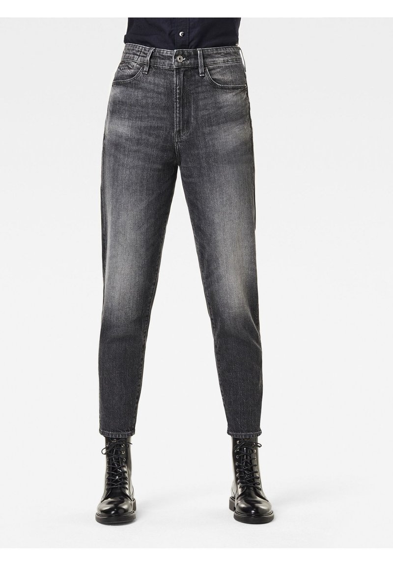 Jeans de denim negro con un corte ajustado, cintura de altura media y un suave desvanecimiento. Cuenta con bolsillos frontales, cierre de botón y dobladillos ajustados.