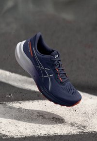 Baskets de course navy avec tige en mesh et accents orange. Dotées d'une épaisse semelle intermédiaire blanche et d'une semelle extérieure texturée noire pour une meilleure adhérence.