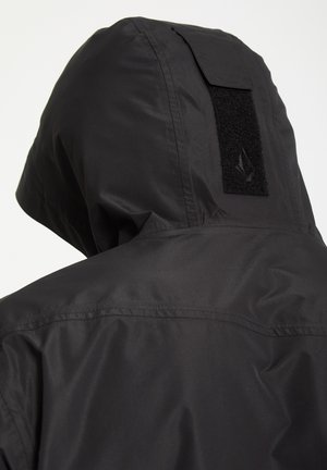 Black waterproof jacket featuring a hood with a hook-and-loop closure and smooth, textured fabric for durability.