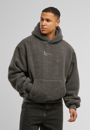 Gray fleece hoodie with a hood, ribbed cuffs, and a front pocket. Features a simple logo in white on the chest. Soft, textured fabric.