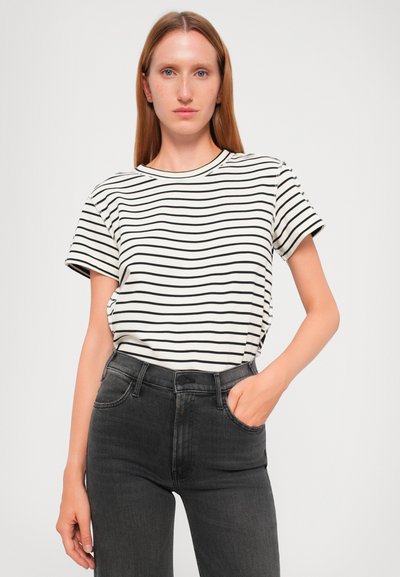 Black and white striped t-shirt with short sleeves and a crew neck, paired with high-waisted dark jeans. Smooth cotton texture, casual fit.