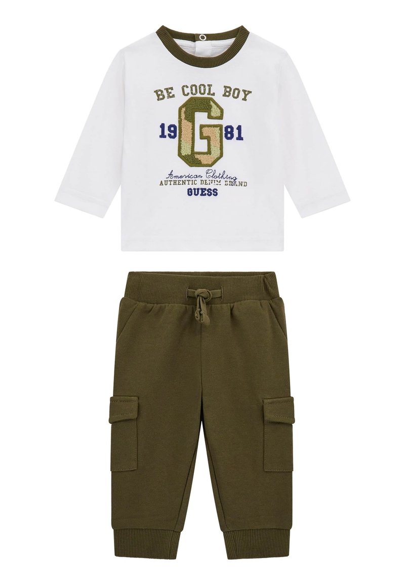 Chemise blanche à manches longues avec un motif imprimé vert et bleu marine, associée à un pantalon cargo vert olive avec des poches latérales et une taille élastique.