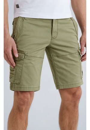 Pantaloncini cargo kaki con tasche laterali a patta indossati da una persona in piedi su uno sfondo uniforme.
