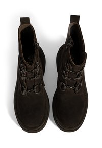 Braune Wildleder-Stiefeletten mit runden Schnürsenkeln und metallischen Ösen, ausgestattet mit einem gepolsterten Kragen und einer strukturierten Sohle für besseren Halt.