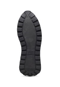 Suola di scarpe in gomma nera con scanalature e creste profonde per la trazione, dotata di un logo al centro e di una superficie testurizzata per una migliore aderenza.