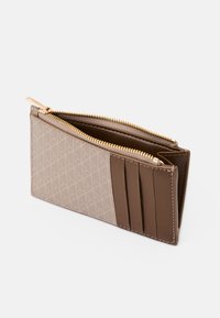 Portefeuille en cuir marron avec un extérieur à motif géométrique, fermeture éclair et plusieurs emplacements pour cartes d'un côté. Texture lisse et forme compacte.