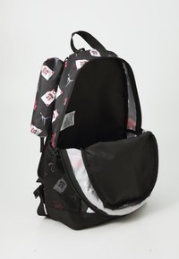 Schwarzer Rucksack mit Grafikdruck, der Basketballtrikots und Logos zeigt. Mit Reißverschluss oben, geräumigem Innenraum, Netzseitentasche und gepolsterten Riemen.