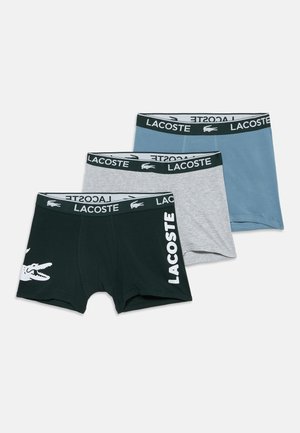Drei Paar Lacoste Boxershorts in Schwarz, Grau und Blau mit gebrandeten Bundstreifen und Logodetails vorne und am Bund.