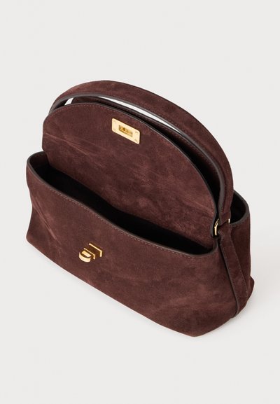Sac à main en daim marron foncé avec dessus arrondi, fermoir doré et une poignée unique, présenté ouvert avec la doublure intérieure visible.