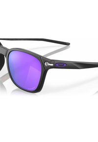 Gafas de sol negras con lentes espejados morados, diseño angular, acentos de goma en las varillas y detalle de logo grabado en el marco.