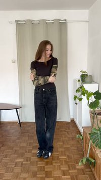 Melnas augstās vidukļa džinsus ar brīvu piegulumu, apvienojot ar brūnu t-kreklu ar kamuflāžas rakstu garām piedurknēm. Melnas un baltas sporta kurpes.