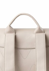 Béžová kožená taška s hladkým povrchem, s kulatými rukojetmi a dvěma širokými popruhy, zvýrazněná švy a geometrickým vzorem.