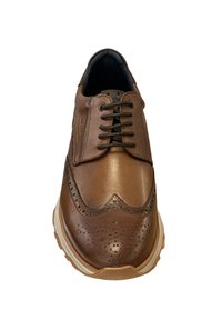 Bruine leren brogue schoen met decoratieve perforaties, ronde neus en zwarte veters. Rubber zool met een lichte verhoging. Gladde textuur.