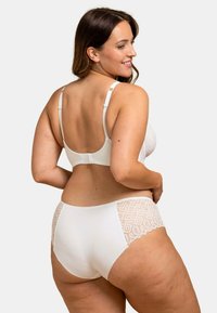 Soutien-gorge blanc et slip taille haute assorti, ornés d'accents en dentelle avec des motifs géométriques. Texture lisse, bretelles réglables et fermeture à crochets.