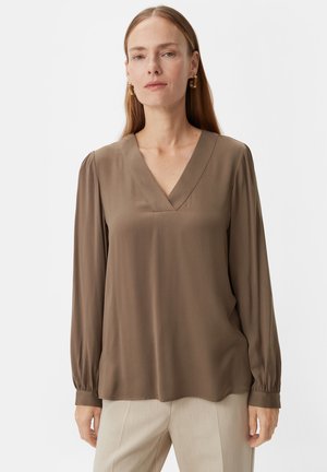Brown, long-sleeve blouse with a V-neck, made from a smooth, lightweight fabric. Features gathered sleeves and a slightly curved hemline.