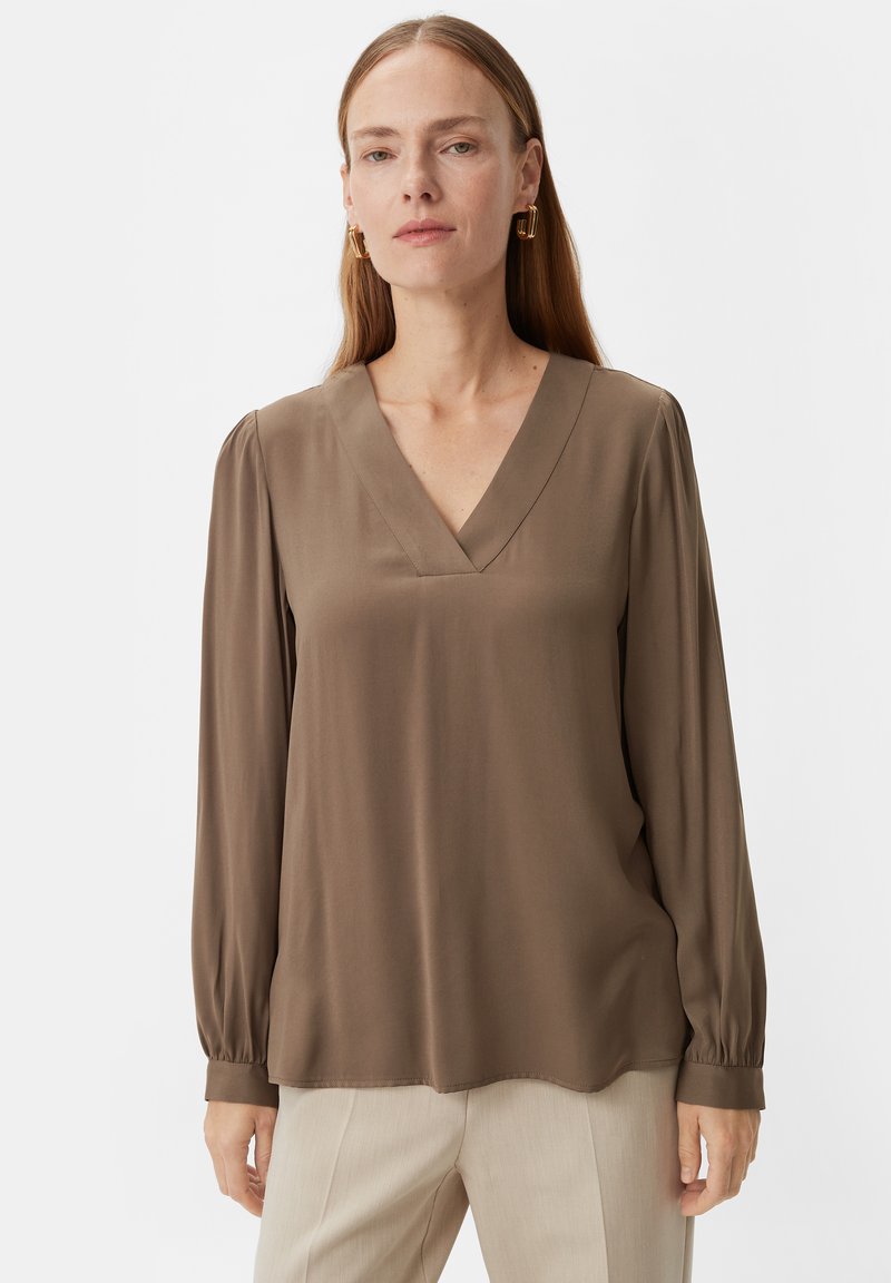 Braune Bluse mit langen Ärmeln und V-Ausschnitt, gefertigt aus einem glatten, leichten Stoff. Sie hat geraffte Ärmel und einen leicht geschwungenen Saum.