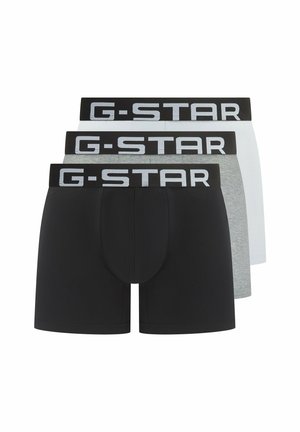 Three men's boxer briefs in black, gray, and white with wide black waistbands featuring large white "G-STAR" logos.