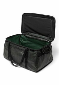 Sac de voyage à motif vert avec des sangles et des fermetures éclair noires, présentant un dessus ouvert et un intérieur spacieux doublé de tissu vert.