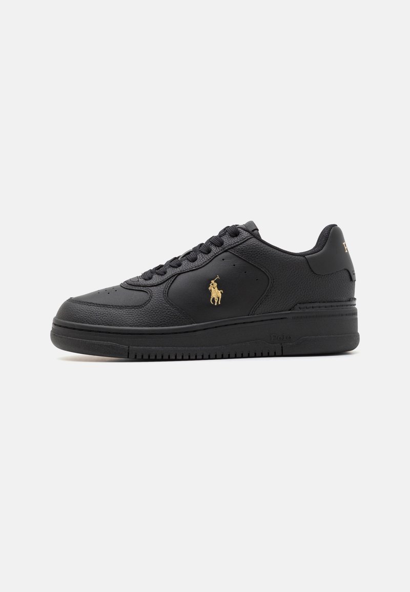 Black leather sneaker with a textured finish, featuring a gold logo on the side, round toe, and black rubber sole with grooves.