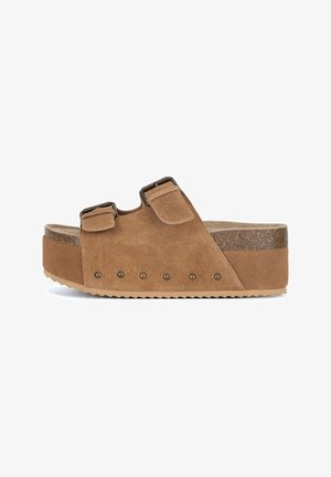 Sandalias plataforma de ante marrón con dos tiras ajustables, hebillas metálicas y tachuelas decorativas. Base texturizada con suela estriada.