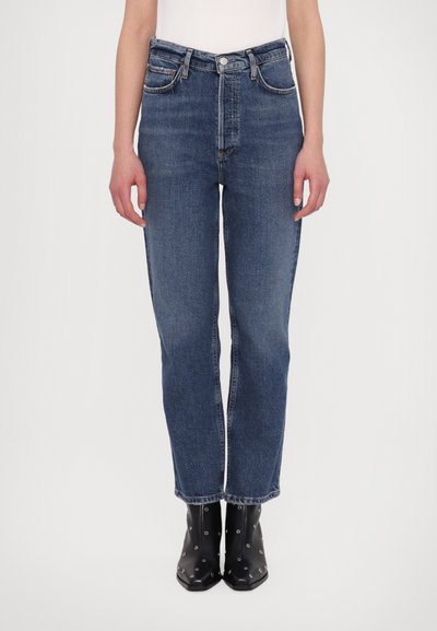 Højttaljede blå denimjeans med en afslappet pasform, fem lomme-design og subtil lysning. Matchet med sorte ankelstøvler med sølvdetaljer.
