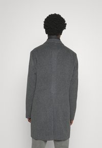 Cappotto di lana grigio con vestibilità su misura, design a un solo petto e texture liscia. Presenta un colletto a punte e una lunghezza intermedia.