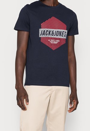 Granatowa koszulka z krótkim rękawem z graficznym wzorem z czerwonymi i białymi akcentami. Wykonana z bawełny, z klasycznym okrągłym dekoltem i luźnym krojem.