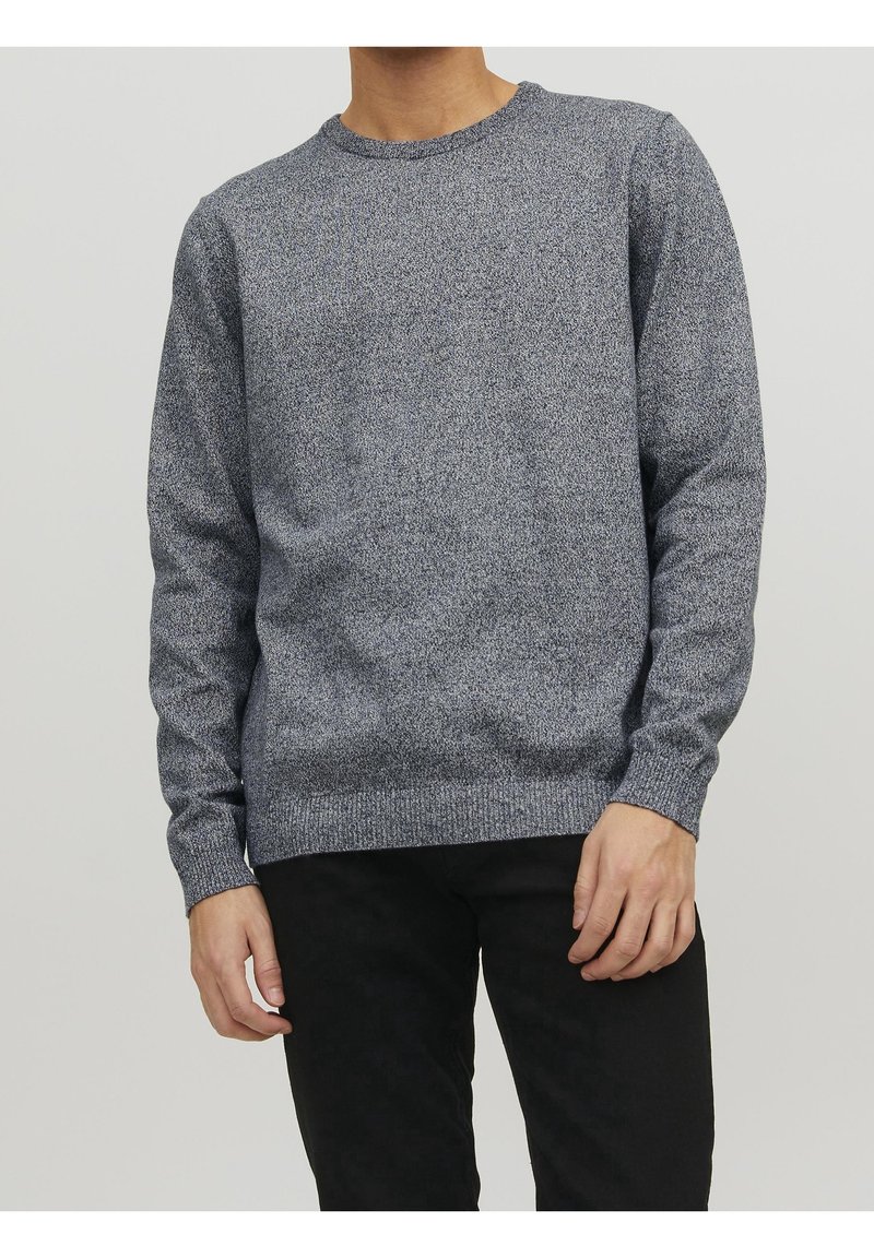 Pull en tricot bleu marine avec une finition texturée, col rond, poignets et ourlet côtelés, assorti à un pantalon noir.