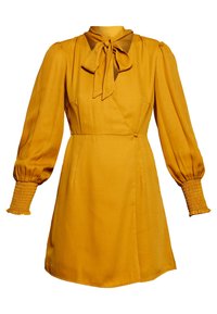 Senapsgul klänning med långa puffärmar, smockade ärmslut och detalj med knyt kring halsen. Tillverkad av ett mjukt, lätt material.