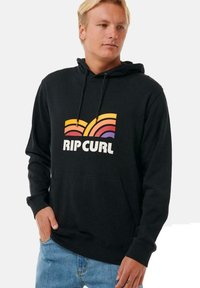 Sudadera con capucha negra y un bolsillo canguro en el frontal, presenta un colorido logo retro con líneas curvas en naranja, rosa y púrpura.