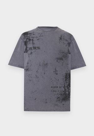 Maglietta grigia a maniche corte con texture nere usurate e testo sbiadito, inclusi "URBAN" e "OCEAN OF LOVE" sparsi sul davanti.