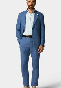 Costume en lin bleu clair avec une veste ajustée et un pantalon assorti. Comprend une chemise boutonnière bleu clair et une ceinture en cuir marron. Design sobre.