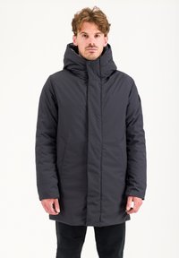 Cappotto lungo nero con colletto alto, realizzato in un materiale sintetico leggero. Presenta tasche laterali, chiusura con zip e cappuccio.