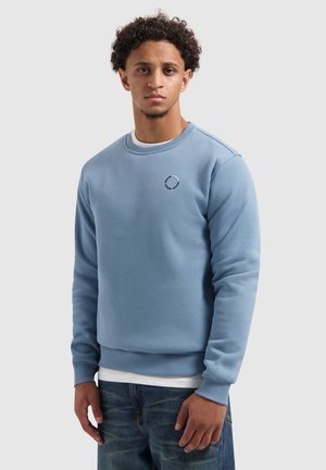 Lichtblauwe katoenen sweatshirt met ribbelboord aan de hals en manchetten. Heeft een cirkelvormig logo in een donkerdere tint op de borst. Casual fit.